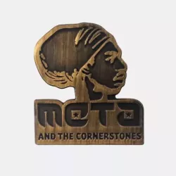 Gold pin of meta and the cornerstones logo