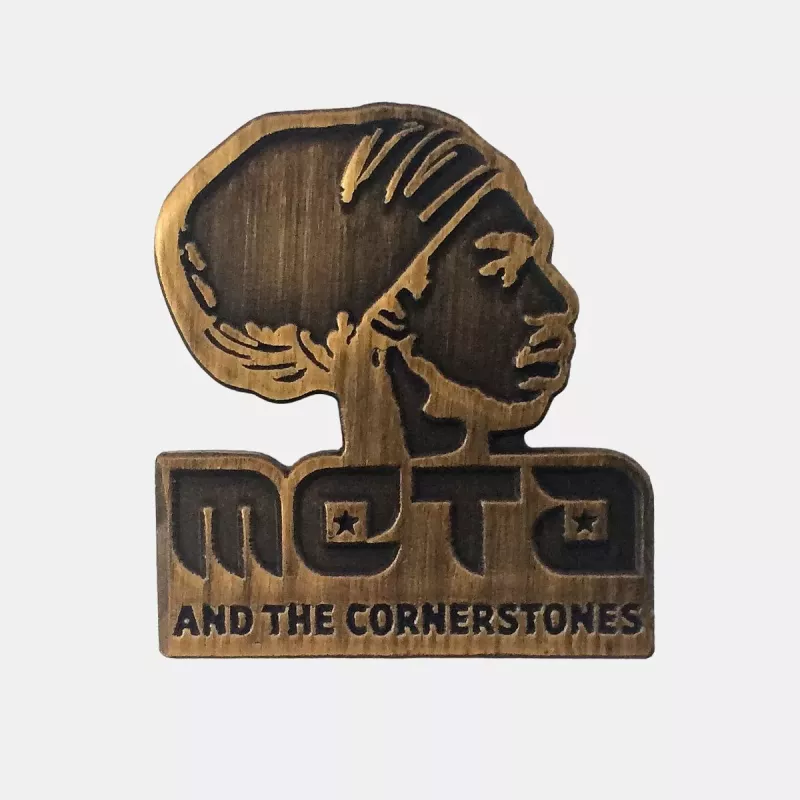 Gold pin of meta and the cornerstones logo